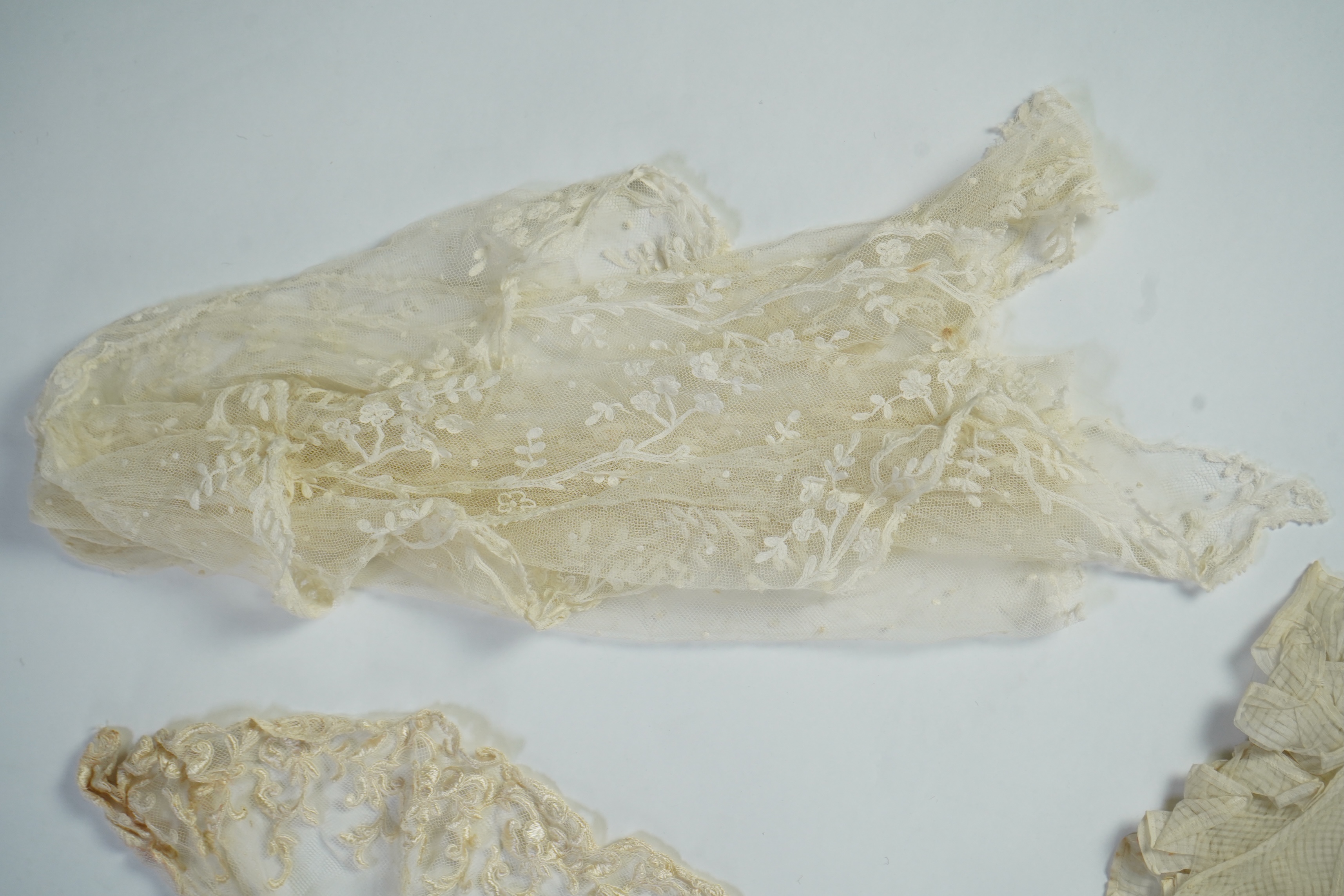 A suitcase containing a cream silk lace skirt to a dress, an Edwardian silk petticoat and various collars, possibly for theatrical use, silk petticoat 96 cm long. Condition - fair